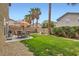 Well-maintained backyard with a lush green lawn and outdoor seating area at 6390 Whispering Clouds Ct, Las Vegas, NV 89141