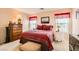 Comfortable bedroom with a red plaid comforter and an upholstered bench for comfortable seating at 6390 Whispering Clouds Ct, Las Vegas, NV 89141