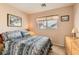 Cozy bedroom features floral bedding, neutral walls and a window for natural light at 6390 Whispering Clouds Ct, Las Vegas, NV 89141