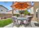 Inviting patio area featuring a round table with chairs and an umbrella for shade at 6390 Whispering Clouds Ct, Las Vegas, NV 89141