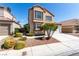 Two-story home with desert landscaping, a two-car garage, and a neutral color scheme at 6428 Yarmouth Dr, Las Vegas, NV 89108