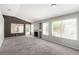 Spacious carpeted living room with large windows, fireplace, and sliding glass doors at 6428 Yarmouth Dr, Las Vegas, NV 89108