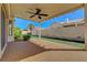 Charming back patio featuring a ceiling fan, outdoor lighting, and well-maintained artificial turf at 7817 Safari Ln, Las Vegas, NV 89129