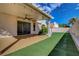 The covered back patio offers an outdoor ceiling fan, lighting, and artificial turf at 7817 Safari Ln, Las Vegas, NV 89129