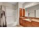 Bathroom with wood-look floors has a tub, shower, vanity and framed mirror at 7817 Safari Ln, Las Vegas, NV 89129