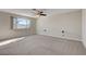 Bright bedroom with large window offering scenic views, carpeted floors, and a ceiling fan at 7817 Safari Ln, Las Vegas, NV 89129
