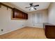 A cozy bedroom featuring hardwood floors, custom cabinets, and a ceiling fan for added comfort at 7817 Safari Ln, Las Vegas, NV 89129