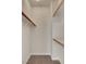 A carpeted walk-in closet features wall-mounted wooden rods and built in shelves at 7817 Safari Ln, Las Vegas, NV 89129