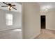 Hallway with a view into a bedroom featuring a ceiling fan and natural light at 7817 Safari Ln, Las Vegas, NV 89129