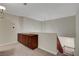 A carpeted hallway with a half wall overlooking the staircase and a dark cabinet for storage at 7817 Safari Ln, Las Vegas, NV 89129