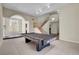 Spacious recreation room with a pool table, carpet, and natural light, perfect for entertaining guests at 7817 Safari Ln, Las Vegas, NV 89129