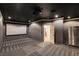 Home theater with projector, screen, dark walls, refrigerator, and tiered seating at 7817 Safari Ln, Las Vegas, NV 89129