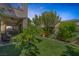 Landscaped backyard with a covered patio and manicured green lawn at 7872 Regency Park St, Las Vegas, NV 89149