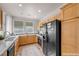 Well-lit kitchen with wooden cabinets, black appliances, and a practical layout perfect for cooking at 805 Dana Hills Ct # 104, Las Vegas, NV 89134