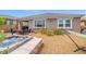Well-maintained backyard with a hot tub, fire pit, and hammock, offering a serene and inviting outdoor space at 8058 Big Skye Ranch St, Las Vegas, NV 89166