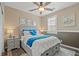 Cozy bedroom with a ceiling fan and natural light, offering a relaxing space with stylish décor and a comfortable bed at 8058 Big Skye Ranch St, Las Vegas, NV 89166
