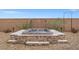 Inviting stone hot tub with decorative screen and surrounding desert landscaping for a relaxing outdoor experience at 8058 Big Skye Ranch St, Las Vegas, NV 89166