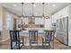 Bright kitchen featuring a large island, stainless appliances and modern pendant lighting at 8058 Big Skye Ranch St, Las Vegas, NV 89166