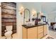 Bathroom featuring rustic wood wall, marble sinks, and arched mirrors at 8091 Mosaic Sunrise Ln, Las Vegas, NV 89166