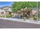 Two-story home with a two-car garage, a mature shade tree and manicured landscaping at 8091 Mosaic Sunrise Ln, Las Vegas, NV 89166