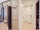 Hallway featuring tiled flooring, access to bathroom and kitchen with modern refrigerator and cabinets at 8091 Mosaic Sunrise Ln, Las Vegas, NV 89166