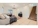 Bright living room with tile flooring, neutral walls, and a staircase leading to the upper level at 8091 Mosaic Sunrise Ln, Las Vegas, NV 89166