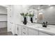 Bright bathroom with a double vanity featuring white cabinets, quartz countertops, and modern fixtures at 84 Via Franello, Henderson, NV 89011