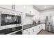 This modern kitchen features stainless steel appliances, white cabinets, dark countertops, and stylish tile backsplash at 84 Via Franello, Henderson, NV 89011