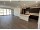 Open-concept kitchen featuring stainless steel appliances, a center island, and sliding doors leading to the backyard at 84 Via Franello, Henderson, NV 89011
