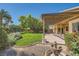 Spacious backyard featuring a covered patio, manicured lawn, and mature trees at 8840 Arroyo Azul St, Las Vegas, NV 89131