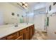 Clean bathroom with double sinks, wood cabinetry, framed mirrors, and a shower/tub combo with a shower curtain at 8840 Arroyo Azul St, Las Vegas, NV 89131