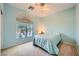 Comfortable bedroom with plush carpeting, a ceiling fan, and a large window providing ample natural light at 8840 Arroyo Azul St, Las Vegas, NV 89131