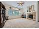Bright living room featuring plush carpeting, a fireplace, and large windows for natural light at 8840 Arroyo Azul St, Las Vegas, NV 89131