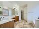 Bright main bathroom with double sinks, a large mirror, wooden cabinets, separate tub, and a private toilet area at 8840 Arroyo Azul St, Las Vegas, NV 89131