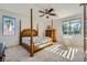 Cozy main bedroom with a four-poster bed, neutral carpet, and bright natural light from the two large windows at 8840 Arroyo Azul St, Las Vegas, NV 89131