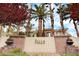 Landscaped community sign for 'The Falls' with lush plantings and mature trees at 9050 W Warm Springs Rd # 1074, Las Vegas, NV 89148
