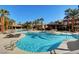 A sparkling community pool surrounded by palm trees and seating areas for relaxation at 9050 W Warm Springs Rd # 1074, Las Vegas, NV 89148