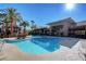 A community pool featuring a sun deck surrounded by tropical palm trees on a sunny day at 9050 W Warm Springs Rd # 1074, Las Vegas, NV 89148
