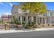 Inviting townhome featuring desert landscaping, green shrubbery, and a beautiful shade tree at 946 Belton Lake Ave, North Las Vegas, NV 89086