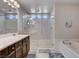 Well-lit bathroom featuring double sinks, glass enclosed shower and separate tub at 9656 Paraiso Springs St, Las Vegas, NV 89139