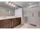 Spacious bathroom with double vanity, large mirror, and glass-enclosed shower at 9656 Paraiso Springs St, Las Vegas, NV 89139