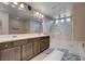 Well-lit bathroom with double sinks, glass enclosed shower, and separate tub at 9656 Paraiso Springs St, Las Vegas, NV 89139
