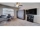 Bedroom featuring neutral carpet, storage unit, ceiling fan, and a mounted television at 9656 Paraiso Springs St, Las Vegas, NV 89139