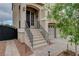 Inviting front entrance with a well-maintained staircase, complemented by decorative lighting and mature trees at 9656 Paraiso Springs St, Las Vegas, NV 89139