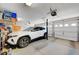 A well-lit, organized two-car garage featuring ample storage space, a white vehicle, and convenient access to the home at 9656 Paraiso Springs St, Las Vegas, NV 89139