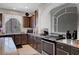 Close-up of a kitchen with dark wood cabinetry, granite countertops, and modern stainless steel appliances at 9656 Paraiso Springs St, Las Vegas, NV 89139
