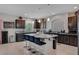 Large kitchen featuring a granite island with seating, dark wood cabinets, and ample counter space at 9656 Paraiso Springs St, Las Vegas, NV 89139