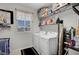 Well-lit laundry room with washer, dryer and storage shelves at 9656 Paraiso Springs St, Las Vegas, NV 89139