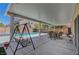 Covered patio with swing and outdoor dining furniture overlooking the sparkling pool at 9656 Paraiso Springs St, Las Vegas, NV 89139