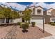 Inviting two-story home featuring a two-car garage, xeriscaping, and tasteful landscaping at 9740 Floweret Ave, Las Vegas, NV 89117